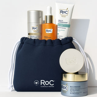 RoC skincare products (Revive + Glow Daily Serum, Hydration+ Moisturizer SPF, Derm Correxion Firming Serum Stick, Derm Correxion Dual Eye Cream, Firm + Lift Anti-Sagging Cream) with a navy holiday cosmetic bag on a white background