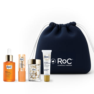 RoC skincare products (Revive + Glow EYE BALM, REVIVE + GLOW DAILY SERUM, LINE SMOOTHING EYE CREAM, LINE SMOOTHING NIGHT SERUM CAPSULES) with a navy holiday cosmetic bag on a white background