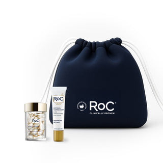 RoC skincare products (Line Smoothing EYE CREAM, LINE SMOOTHING NIGHT SERUM CAPSULES) with a navy holiday cosmetic bag on a white background