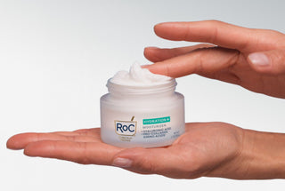 Hands holding a jar of Roc Hydration+ Moisturizers against a white background