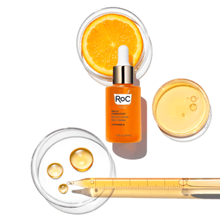 Stylized image of MULTI CORREXION® Revive and Glow Daily Serum with an orange slice and small droplets of orange serum to show serum consistency