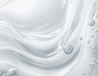 Close-up of white liquid with bubbles on a light gray background
