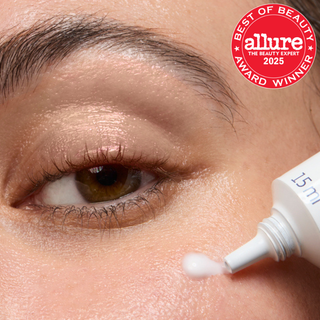 Close-up of a person applying line smoothing eye cream to their eye with 'Allure' award badge.