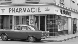 Vintage car parked in front of pharmacy des annees building with 'Pharmacie' sign.