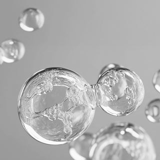 Close-up of clear bubbles against a gray background