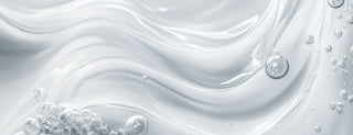 Close-up of white liquid with bubbles on a light gray background