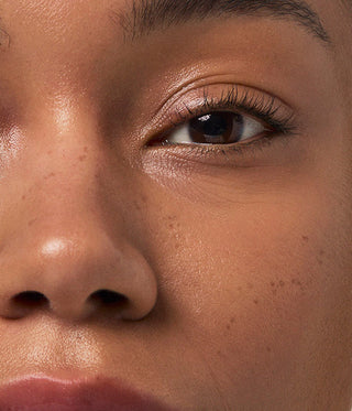 Close-up of a person's eye and nose with a soft focus on the skin texture.