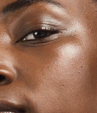 Close-up of a person's eye with dark eyeliner on a blurred background