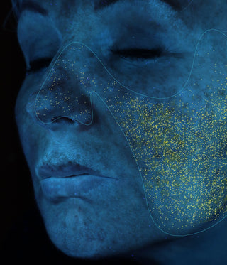 Close-up of a person's face with blue skin analysis on a black background