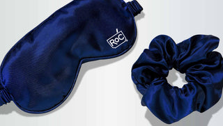 Navy blue sleep mask and scrunchie with 'ROC' branding on a light gray background