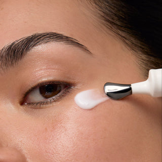 Person applying Derm Correxion Dark Circle Eye Repair Cream to their eye with the metal cooling tip applicator