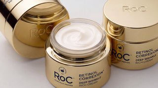 Three gold cosmetic jars of RoC Retinol Correxion Deep Wrinkle Rich Cream on a clean white background, with one open jar showing the white cream inside.