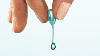 Fingers squeezing product out of MULTI CORREXION® HYDRATE + PLUMP SERUM CAPSULES