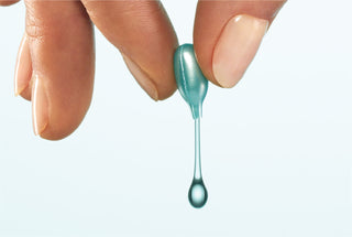 Fingers squeezing product out of MULTI CORREXION® HYDRATE + PLUMP SERUM CAPSULES