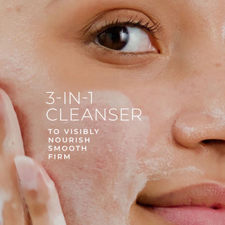 Close-up of a woman applying 3-in-1 Cleanser to her face with overlay text: “3-in-1 Cleanser. To visibly nourish, smooth, firm.”