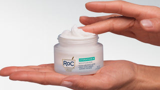 Hands holding a jar of Roc Hydration+ Moisturizers against a white background